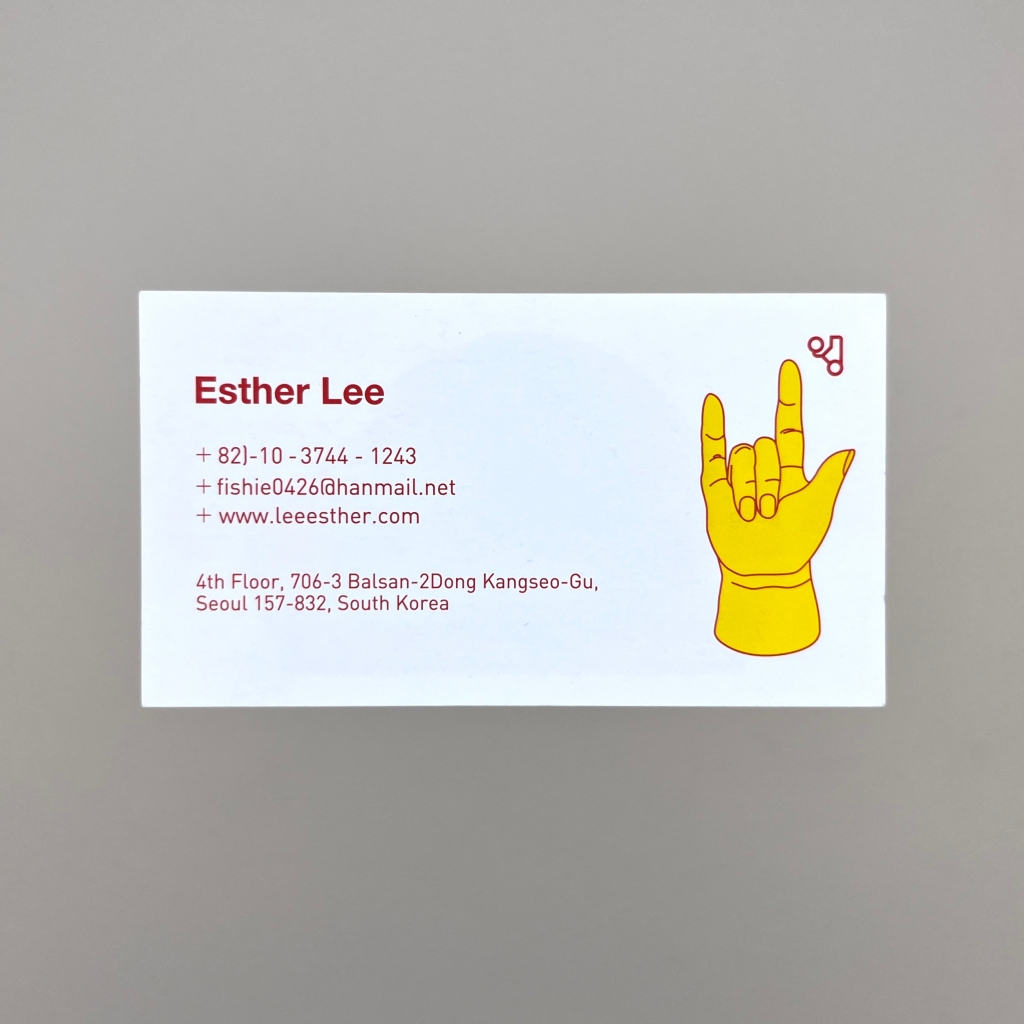 Front of business card with a bright yellow coloured simple illustration a hand doing the American Sign Language "I love you" sign in, with its middle two fingers down, and the other three digits pointing up, next to information about Esther Lee.