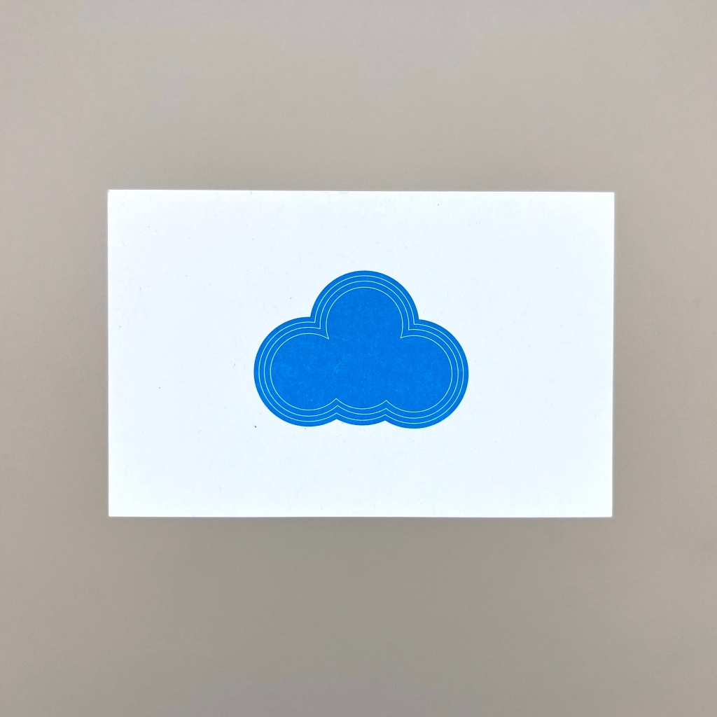 A white business card with an illustrated blue cloud on it