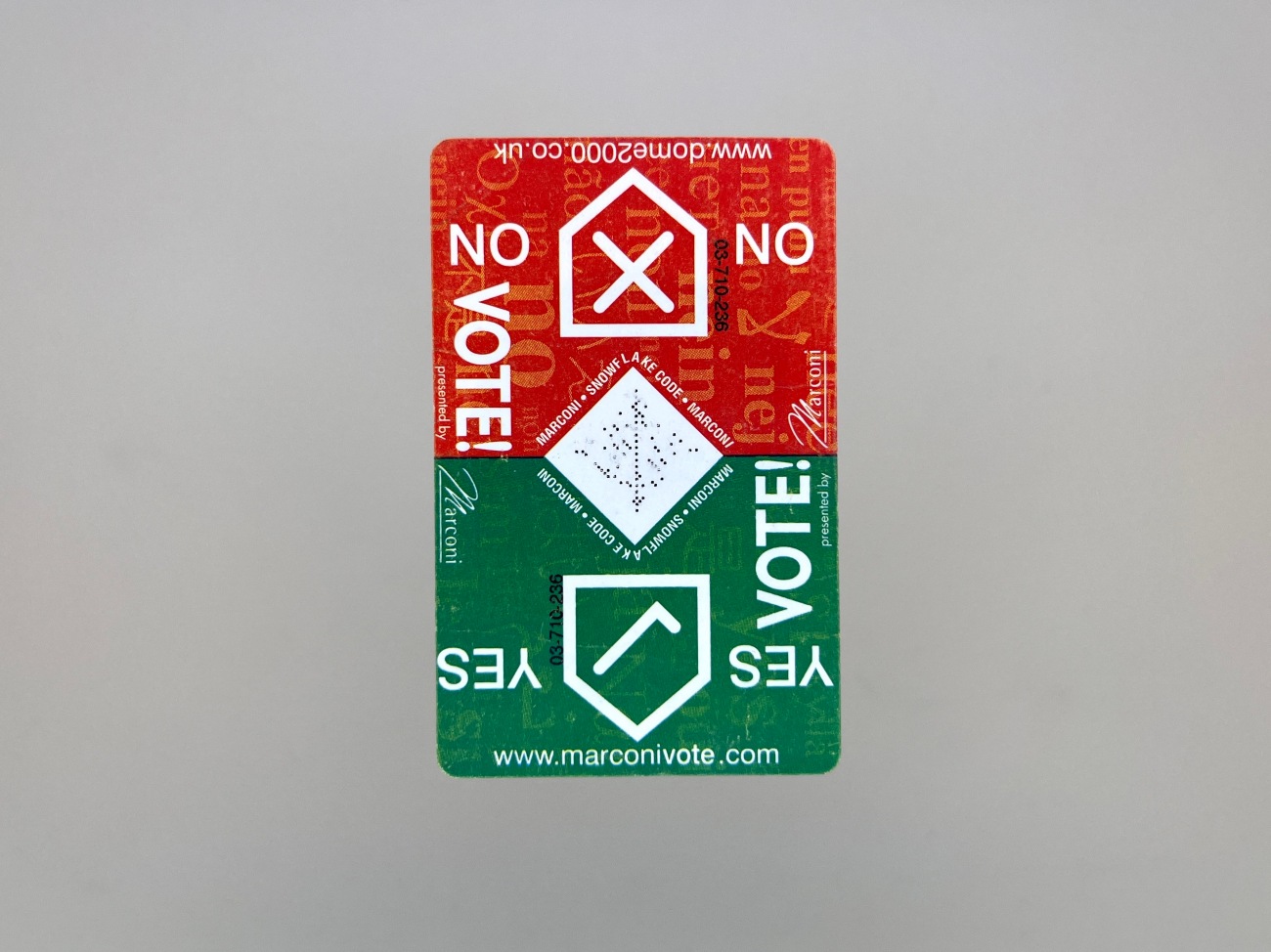 A vertical business card size piece of design with rounded corners. The top is red with an arrow shape pointing up with an X in it and the words No and Vote! along side. The bottom is green with an arrow shape with a tick, and the words Yes and Vote! The URLs marconivote.com and dome2000.co.uk also feature next to small Marconi logotypes. 