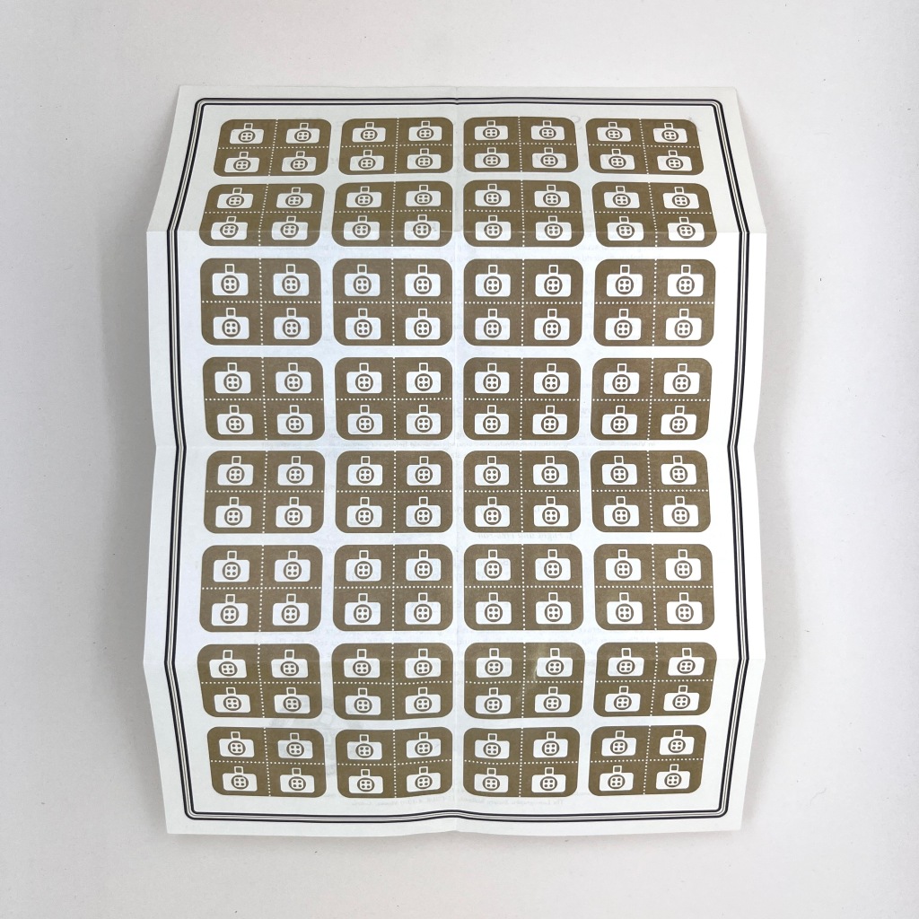 A folded page with a repeated grid of icons of a super sampler Lomo camera across the whole thing 