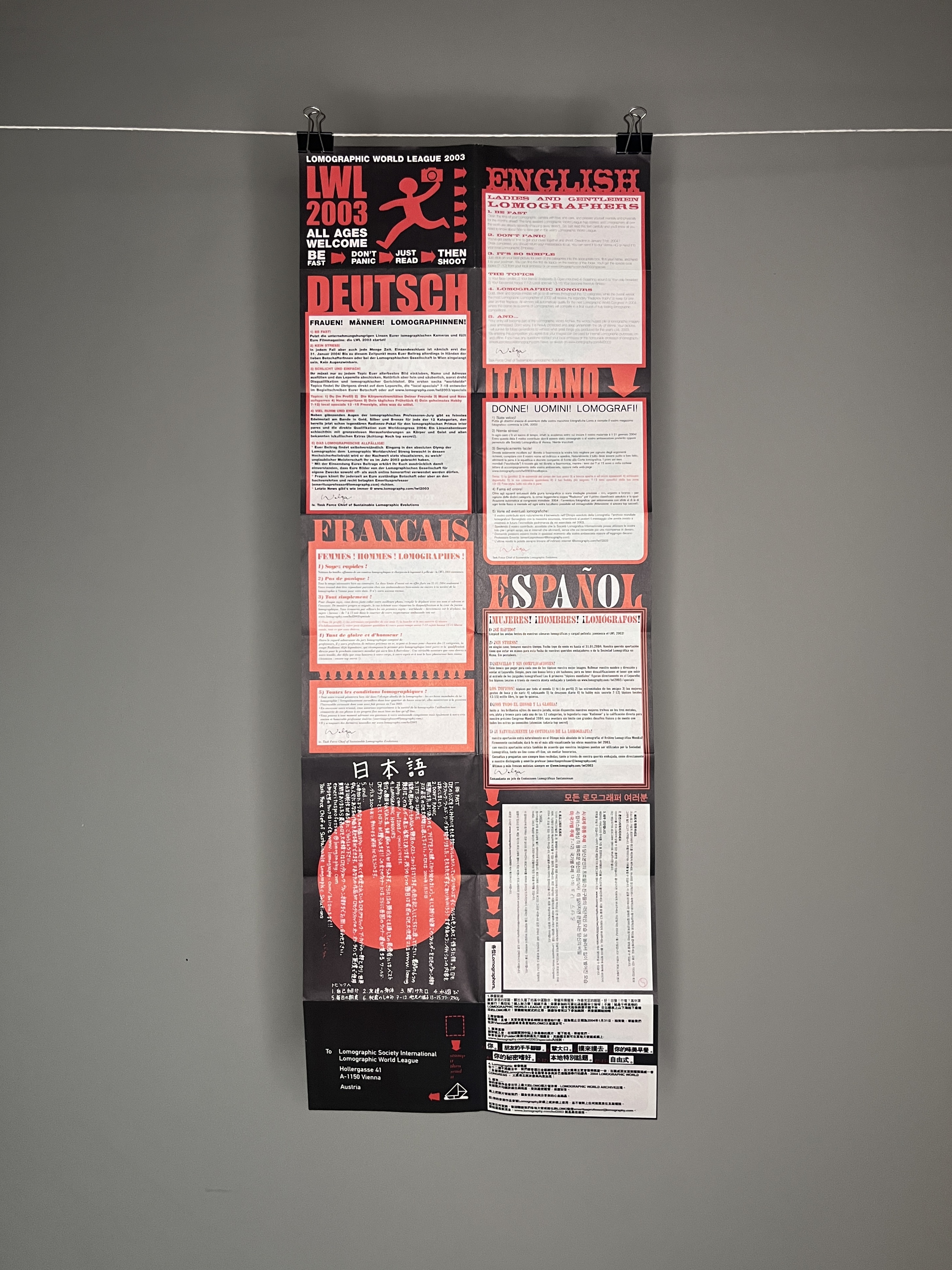 A typographic red white and black long poster covered in the English, Deutsch, Italiano, Francais, Espanol, Chinese and Japanese rules of the competition.  
