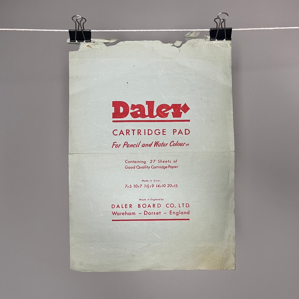 A piece of cartridge paper that is word and rough around the edges. It say Daler, cartridge pad for pencil and water colour etc along with details about the paper size and quantity in red ink 