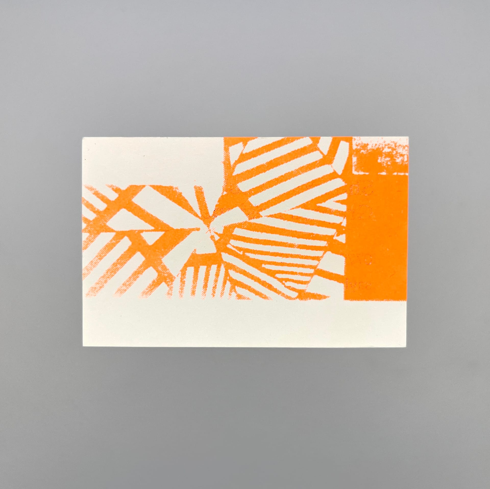 Rear of a beige business card with bright orange abstract and graphic shapes printed on it